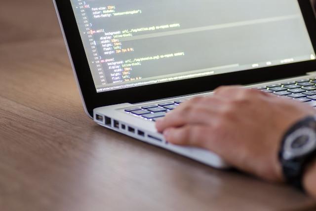 A man writing code on a laptop