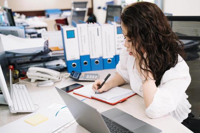 Women in an office writing in a notebook