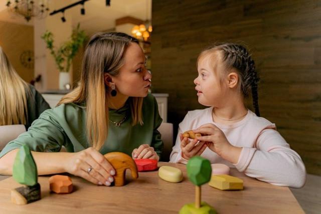 A women playing with a a girl with Downs Syndrome