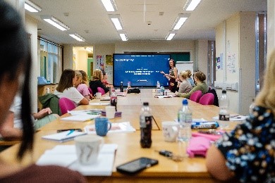 A group of people around a table watching a presentation