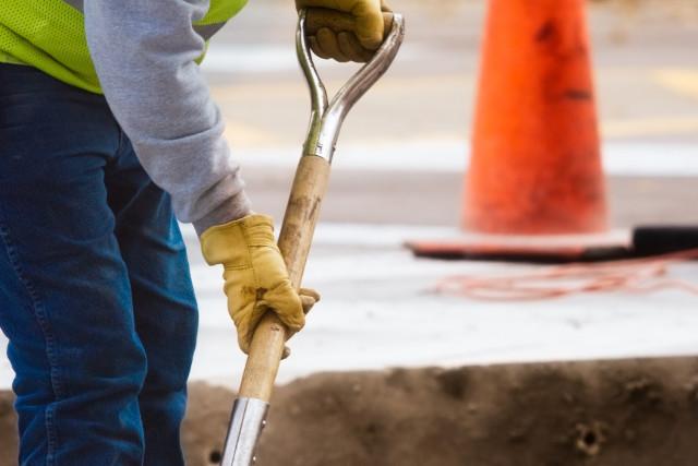 Man digging hole in the road