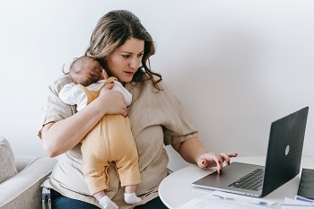 woman holding a bbdy at a laptop