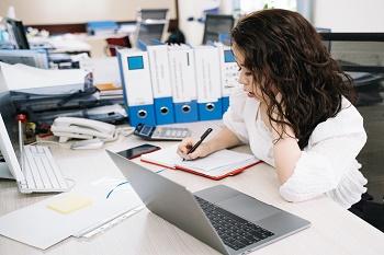 Women in an office writing in a notebook